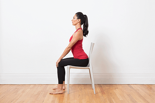 Cat-Cow Yoga Pose demonstrated by a woman seated in a chair
