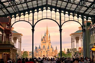 The famous Disney castle with a crowd of people in the foreground.