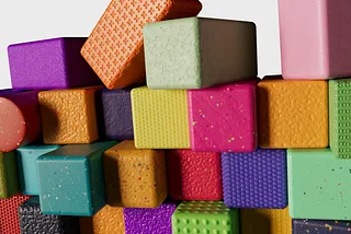 Colorful foam building blocks with various textures stacked and scattered against a white background