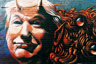 Graffiti painting of Donald Trump sporting horns and a forked tongue on a blue brick wall.