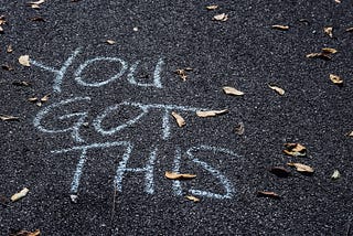 Chalk writing on pavement which reads, “You got this”.