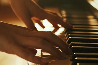 Female hands playing a piano.