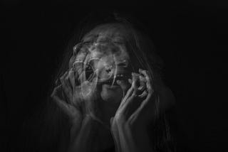 An artistic photo of the upper body of a person screaming in black and white.