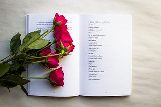 A bundle of roses laying on a book of poems