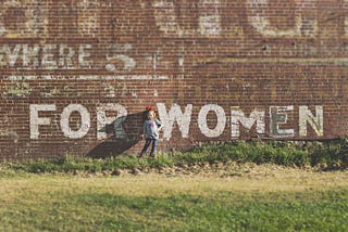Grafitti of the words ‘for women’ on a brick wall