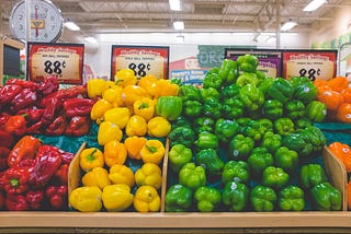 A display of red, yellow, green and orange peppers for sale at a supermarket for 88 cents.