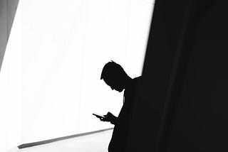 Black and white photo of man on phone discovering the secret to great writing.