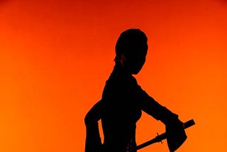 Silhouette of a female warrior is seen weilding a sword, shown against a high-contrast orange background.