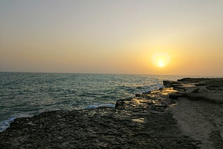 a pretty photo of an ocean with a sun setting on the horizon line