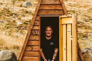 man standing inside a triangular shaped cabin