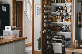 A neat farmhouse kitchen. The well-stocked pantry door is open.