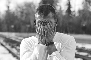 portrait of a man covering his face with his hands