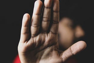 A man holding up his palm to the camera.