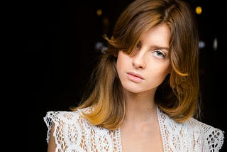 Woman wearing a revealing white lace blouse