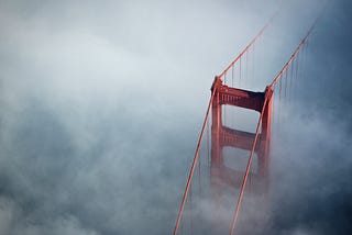 A shot of the Golden Gate Bridge in the fog, taken from an aircraft.