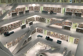 A large and modern library with lot of white ladders and walls