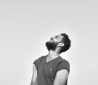 A joyful man looking up and laughing, relaxed and happy