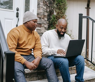 Father and son in front of a laptop.