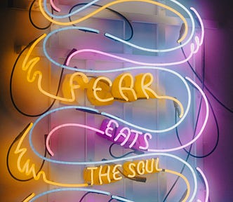 A neon sign that says ‘fear eats the soul’