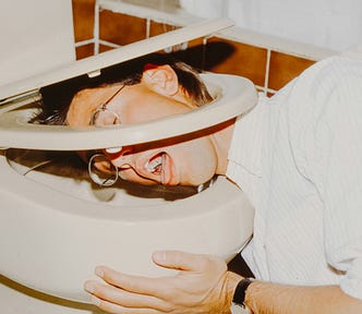 Photo of man throwing up in toilet.