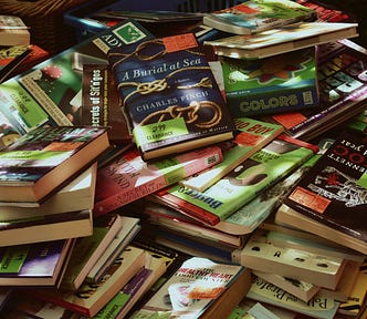 A table with a stack of unorganized books