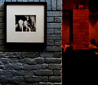 Some framed photographs on a brick wall