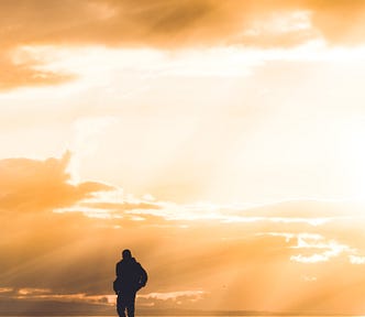 A man walking alone on a beach.