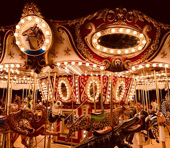 Carousel ride featuring big jungle cats lit up brightly against a night sky.