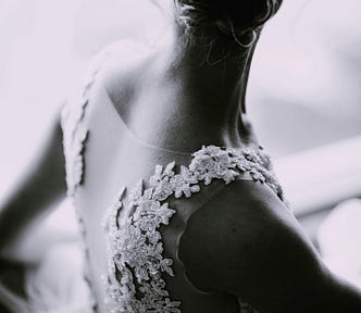 A bride in a white wedding gown looking back
