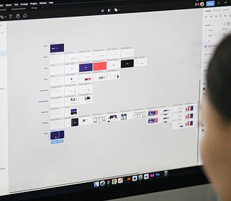 A designer working on in Figma on what it looks like a design system.