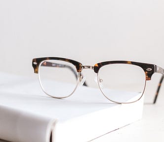 A pair of glasses on a book — or how I switch from reading to writing