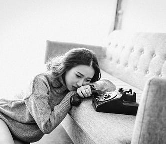 woman couch and phone — she looks sad — the phone looks fake — but it gives the idea that someone is not returning her calls. Most likely because the person is busy reading my substack (https://smillew.substack.com/)
