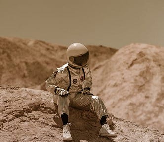 an astronaut doll wearing sneakers, seated on a barren alien landscape