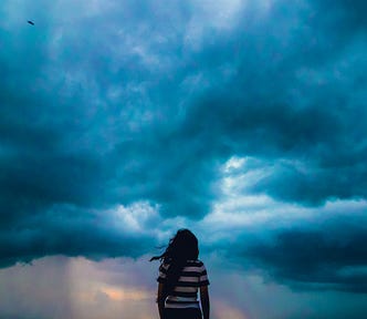 Woman standing in front of a stormy sky