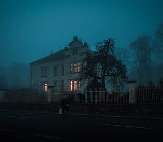 A picture of a dark, freezing, double story house in the middle of the country.
