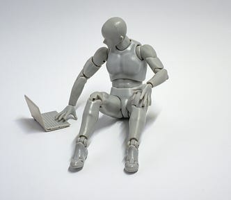 An image of a model of a robot using a model laptop