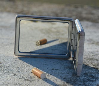 cigarette case on ground, mirror reflecting cigarette butt
