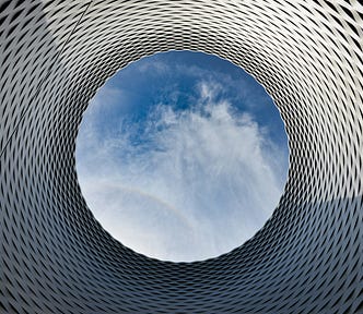 Picture of a view of the sky through a cylindrical, tessellated object