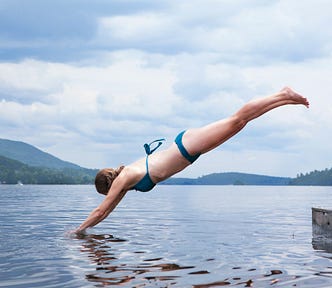 woman in bikini dives into the sea