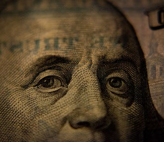 sepia toned image of Ben Franklin from 100 dollar bill.