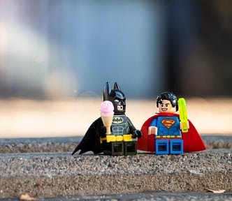 Batman and Superman Lego figures getting curious about curiosity over ice cream
