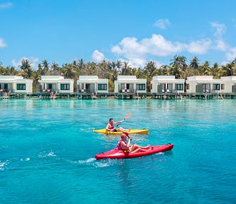 Photographs of two people on kayaks with holiday appartments in the background.