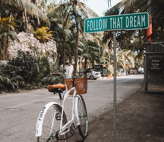 bicycle in front of a ‘follow your dreams’ sign