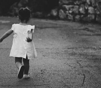 young child runs away. Photo is black and white.