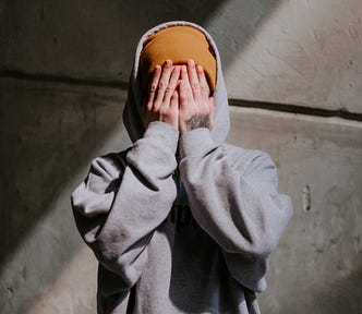 A person covers his or her face with both hands.