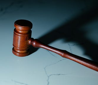 Color photograph of a wooden gavel on a marble tabletop