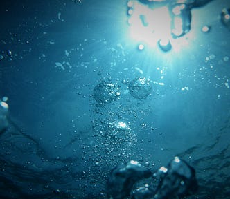 Sunlight viewed from underwater through bubbles.