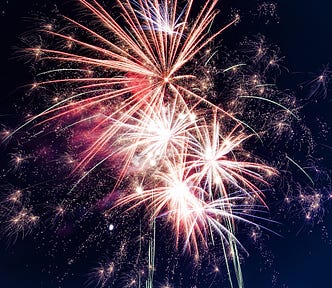 Fireworks explode in the center of the frame. The author has used this image to show the ending of one year and the beginning of new one.