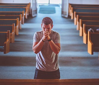 man bowing at the altar, repenting in a church