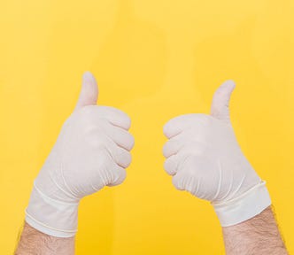 Gloved hands giving the “thumbs up” sign